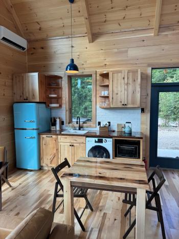 Efficient cabin kitchen with space-saving appliances and a pop of color.
