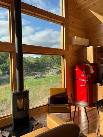 Large windows in our design build cabin with wood burning stove.