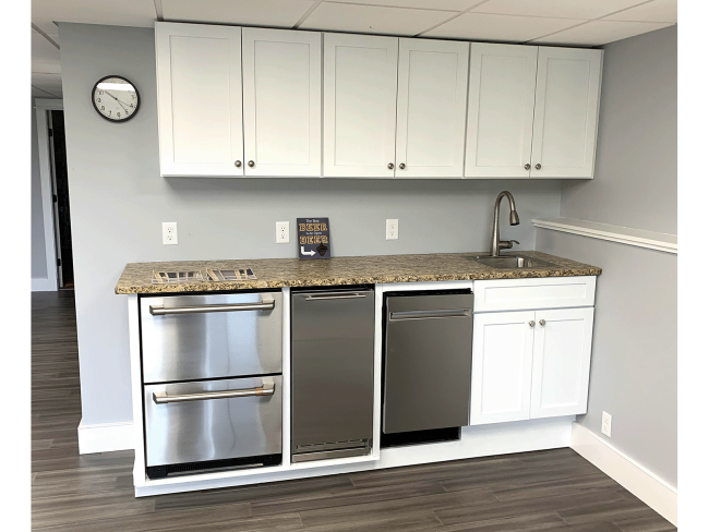 A frontal view of the basement bar that was custom built to accommodate the small appliances, such as mini fridge and dishwasher. New Cabinets are featured as well.