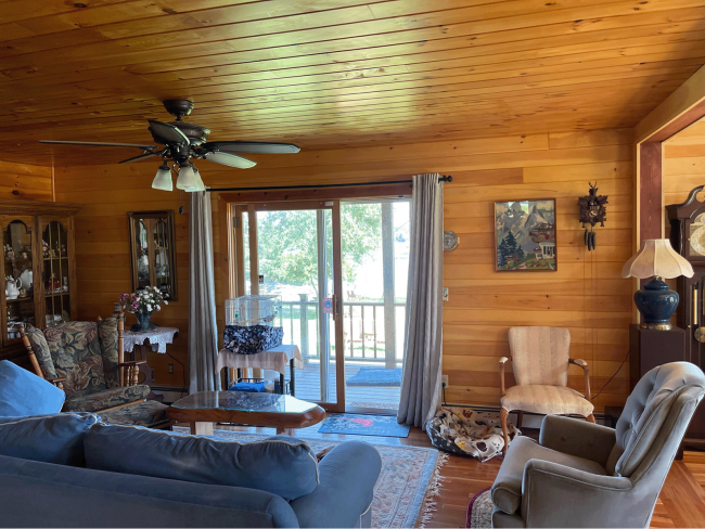 Additional sitting room with finished wood slat ceiling and walls creating a cabin or cottage aesthetic.
