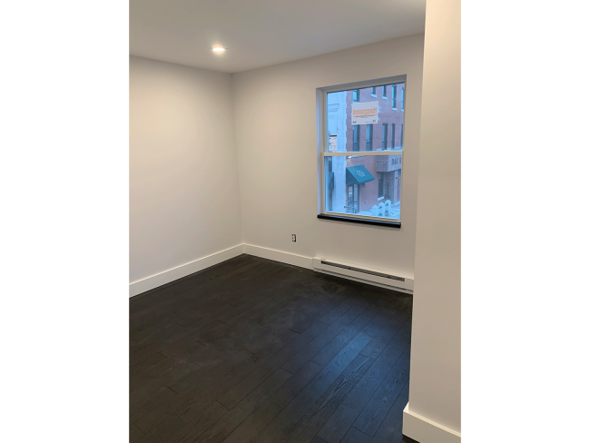 Apartment room with new wood floors and trim.