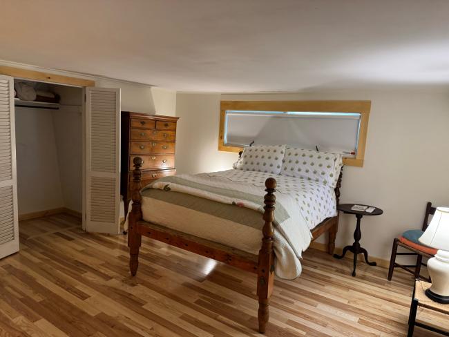 Bedroom with wood-trim window and new floors.
