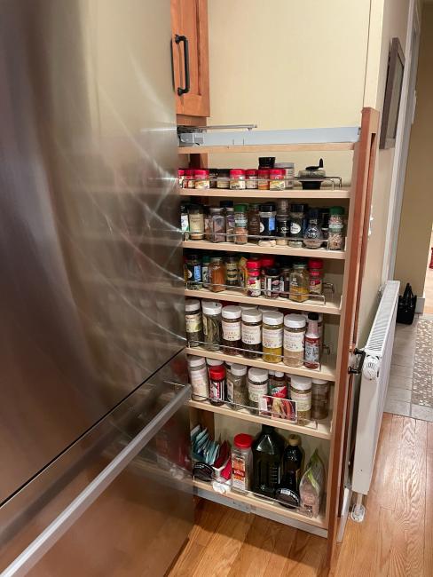 Custom spice rack for space saving solution next to the refrigerator.