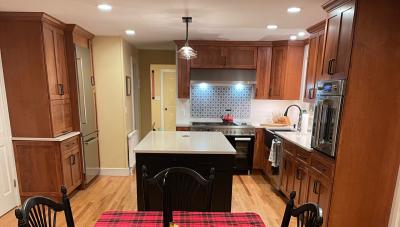 Kitchen remodel with new island, bar cabinetry, appliances, and wood details.